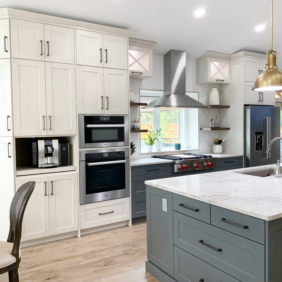 Eat-in kitchen - large transitional galley light wood floor, brown floor and vaulted ceiling eat-in kitchen idea with an undermount sink, shaker cabinets, white cabinets, quartzite countertops, white backsplash, ceramic backsplash, stainless steel appliances, an island and white countertops