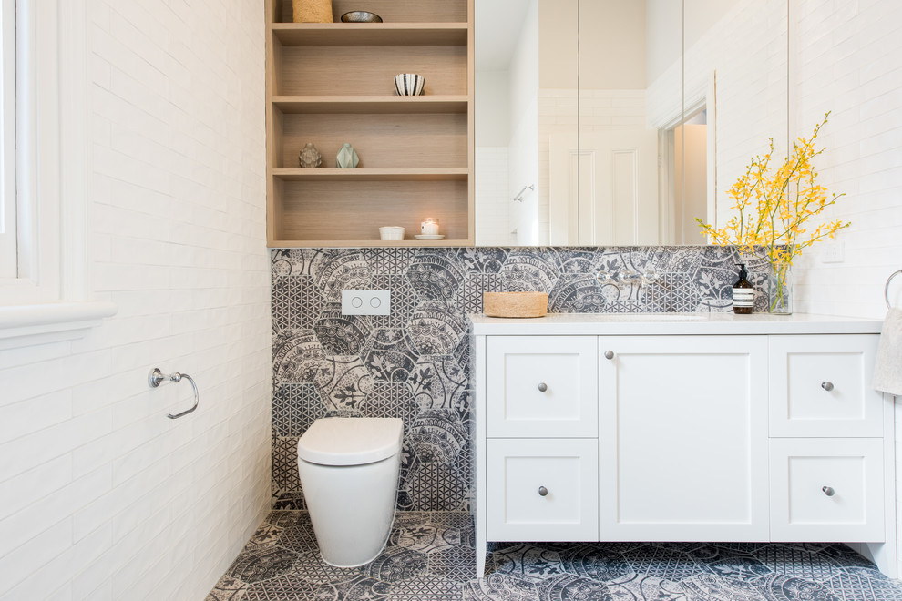 Inspiration for a small transitional bathroom in Melbourne with white cabinets, an undermount sink, engineered quartz benchtops, white walls, porcelain floors, a one-piece toilet, gray tile and shaker cabinets.