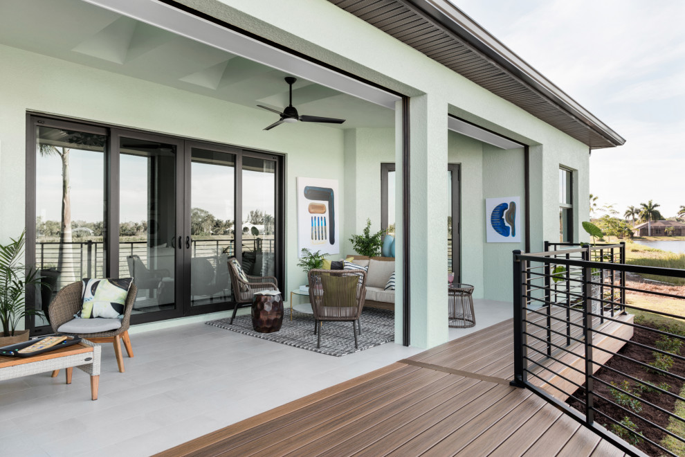 This is an example of a world-inspired back ground level metal railing terrace in Miami with an outdoor kitchen and a pergola.