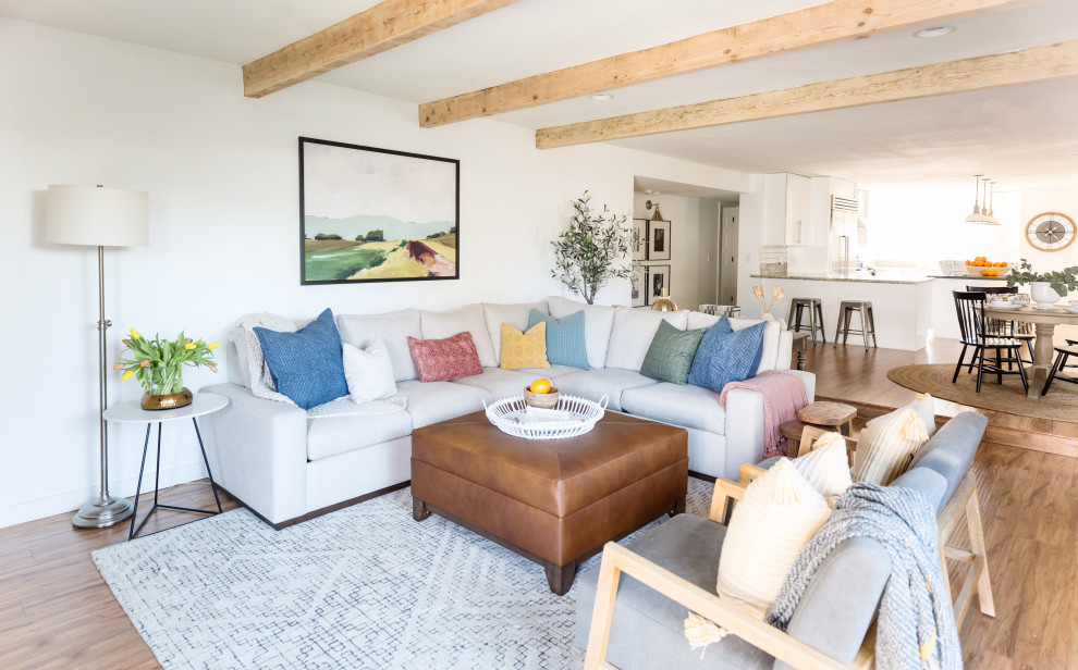 Inspiration for a mid-sized country open concept laminate floor and beige floor living room remodel in Phoenix with white walls, a standard fireplace, a brick fireplace and a wall-mounted tv