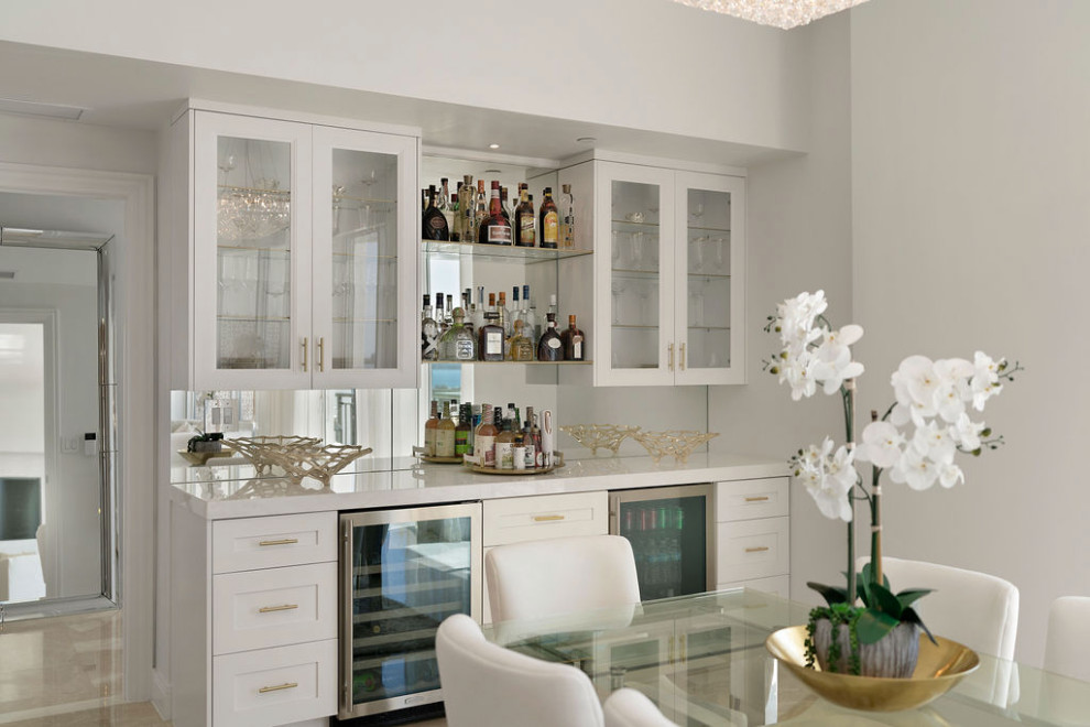 This is an example of a mid-sized contemporary l-shaped home bar in Tampa with an undermount sink, recessed-panel cabinets, white cabinets, quartz benchtops, multi-coloured splashback, stone slab splashback, porcelain floors, beige floor and multi-coloured benchtop.