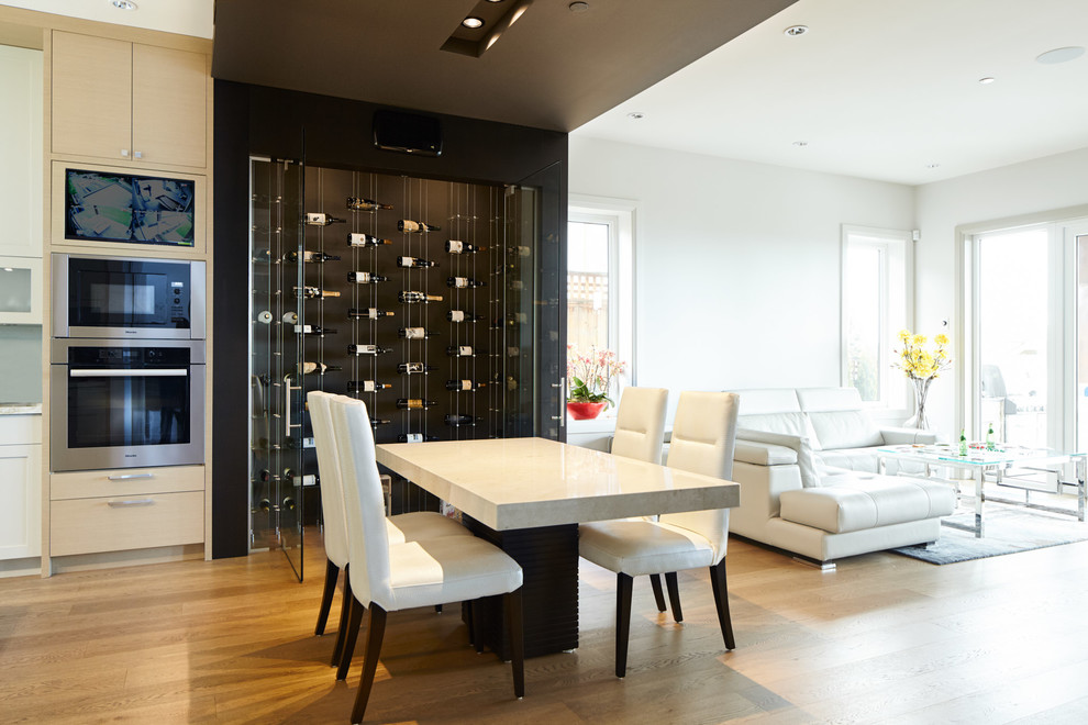 This is an example of a mid-sized contemporary wine cellar in Vancouver with medium hardwood floors, diamond bins and brown floor.