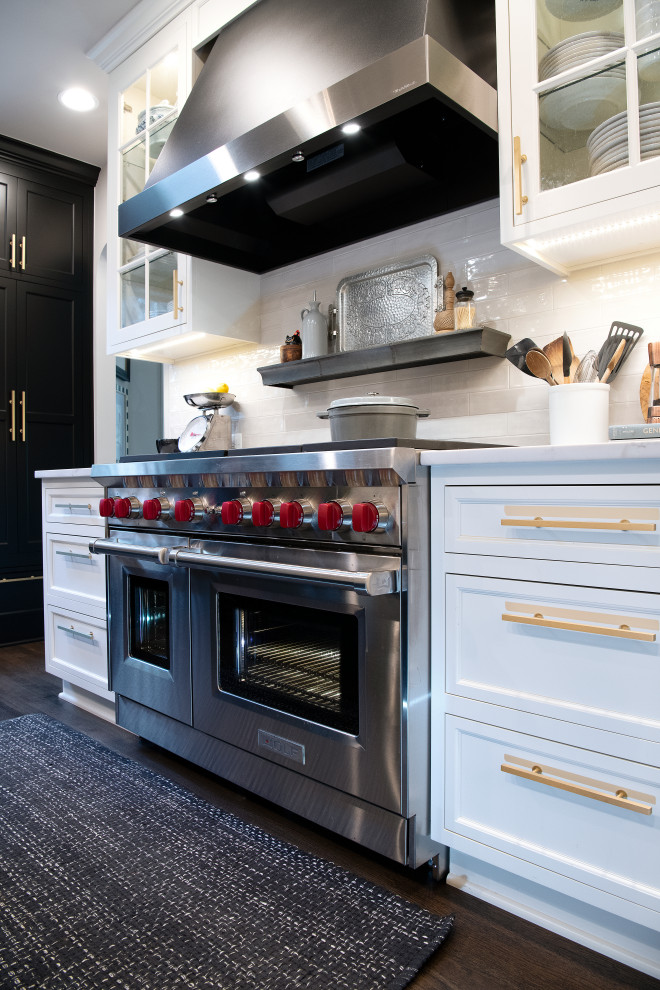 Mid-sized traditional u-shaped separate kitchen in DC Metro with a farmhouse sink, shaker cabinets, black cabinets, quartz benchtops, white splashback, cement tile splashback, panelled appliances, dark hardwood floors, with island, brown floor and white benchtop.