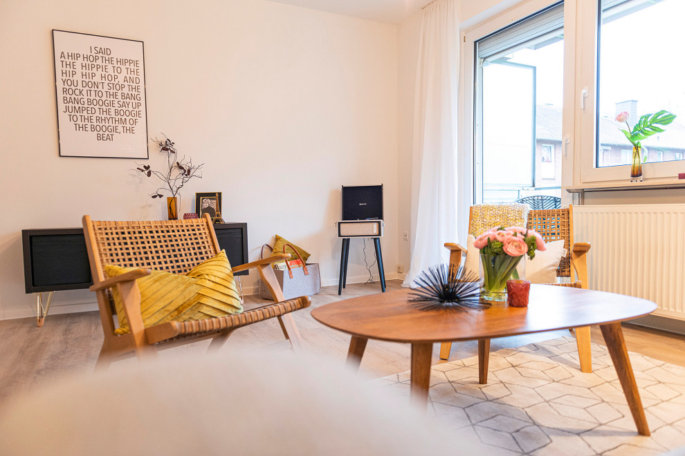 Immagine di un soggiorno minimalista con pareti bianche, pavimento in laminato, pavimento beige e carta da parati