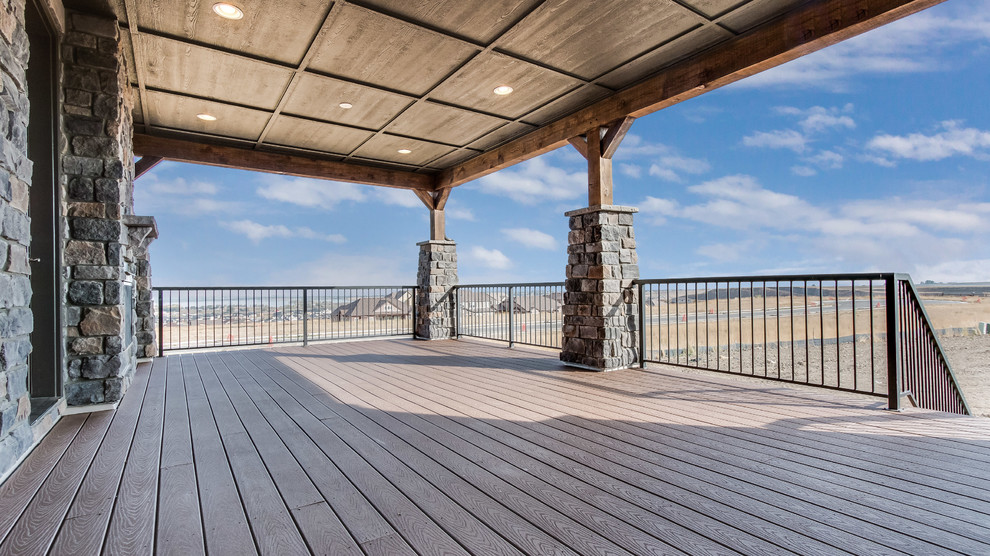 Inspiration for a large transitional backyard deck remodel in Denver with a fire pit and a roof extension