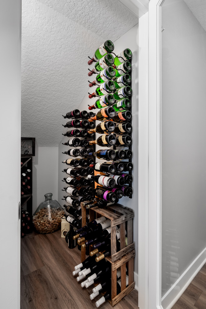 Design ideas for a large wine cellar in Other with vinyl floors, storage racks and brown floor.