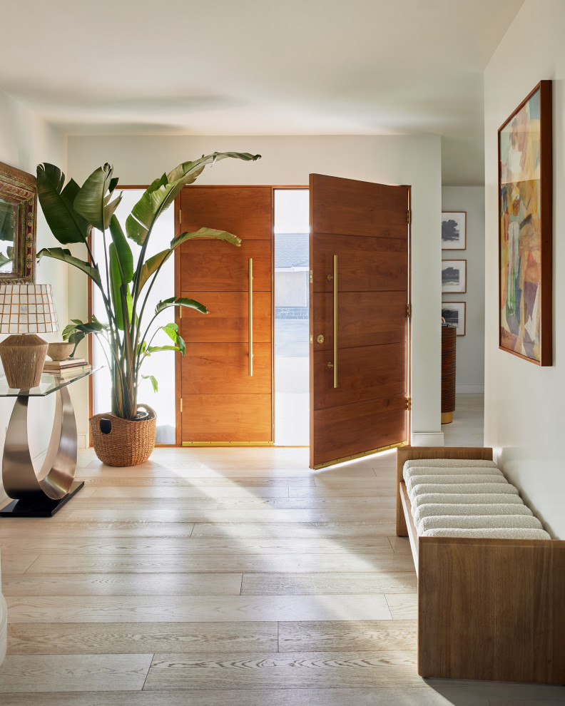 Design ideas for a large midcentury front door in Los Angeles with white walls, light hardwood floors, a double front door, a medium wood front door and beige floor.
