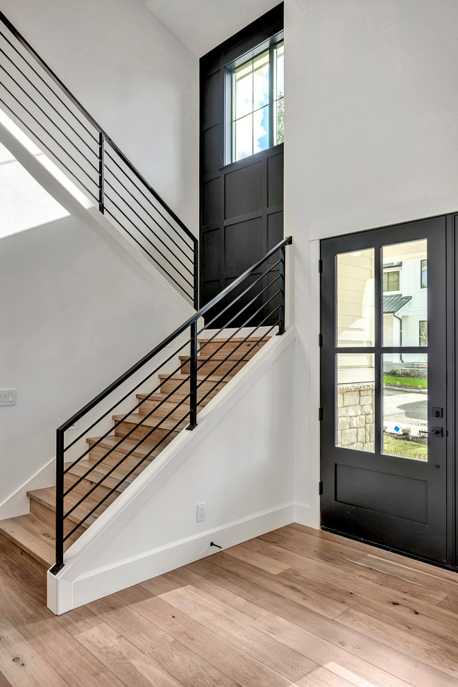 Country wood u-shaped staircase in Seattle with wood risers, metal railing and decorative wall panelling.