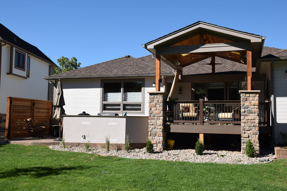 Example of a mid-sized transitional backyard outdoor kitchen deck design in Denver with a roof extension