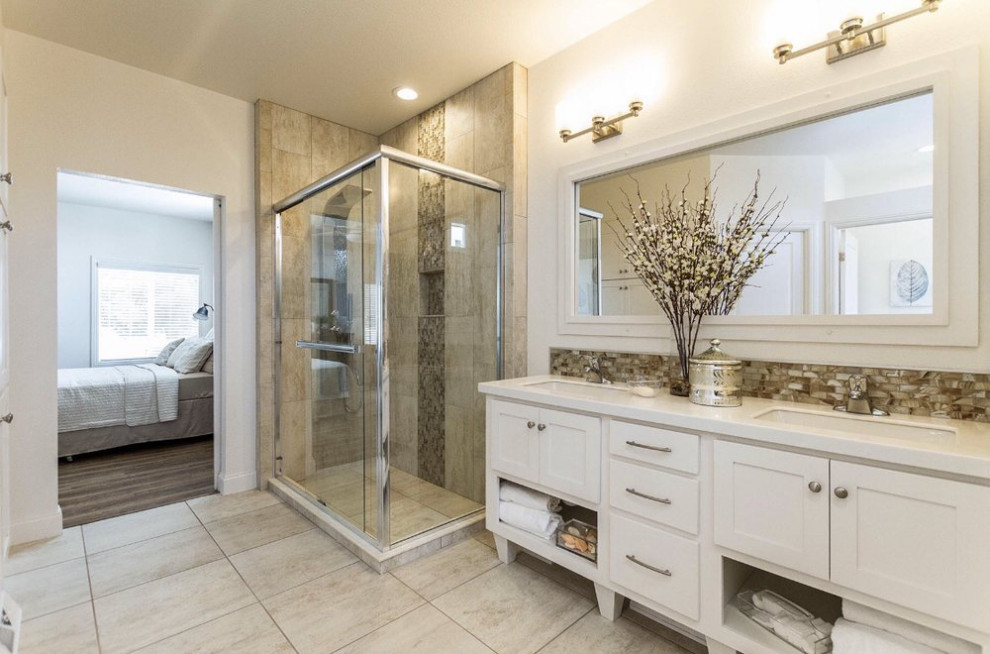 This is an example of a mid-sized traditional master bathroom in Los Angeles with shaker cabinets, white cabinets, a corner tub, a corner shower, brown tile, porcelain tile, beige walls, porcelain floors, an undermount sink, engineered quartz benchtops, beige floor, a sliding shower screen and white benchtops.