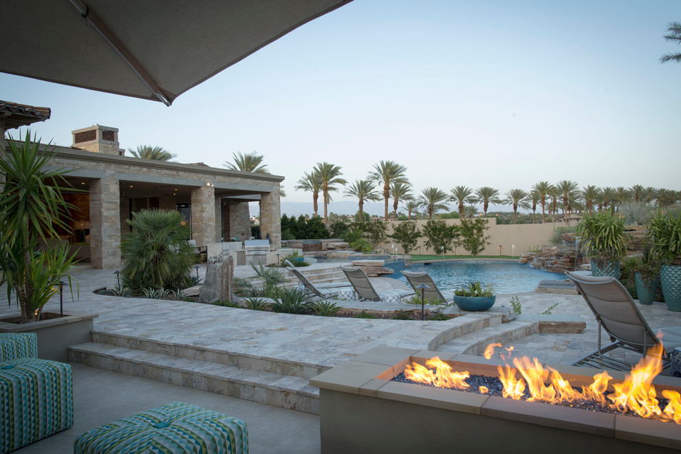 Example of a mid-sized transitional backyard concrete paver and round natural pool fountain design