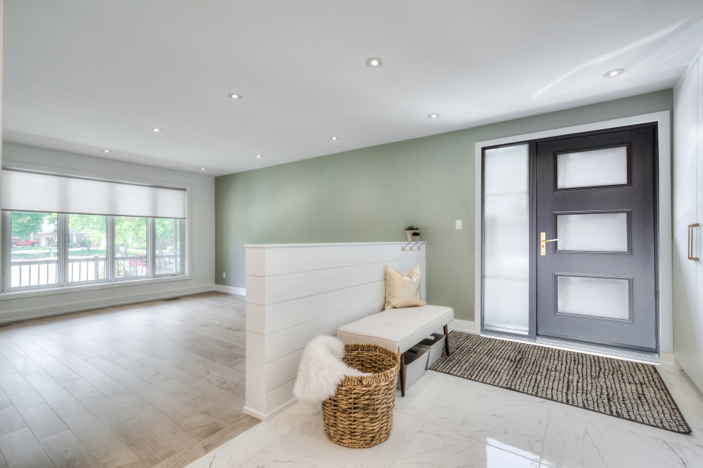 Mid-sized contemporary mudroom in Toronto with green walls, porcelain floors, a black front door and white floor.