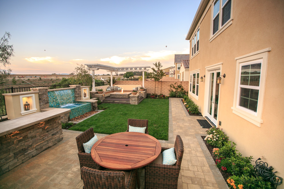 Inspiration for a large transitional backyard garden in San Diego with a water feature and concrete pavers.