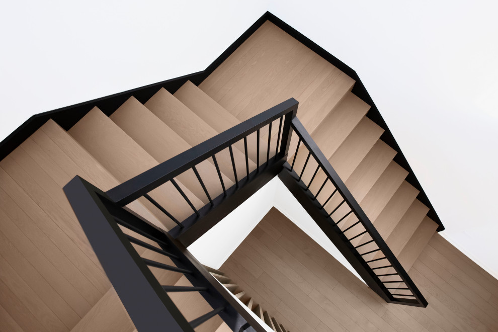シカゴにある高級な広いコンテンポラリースタイルのおしゃれな折り返し階段 (木の蹴込み板、木材の手すり) の写真