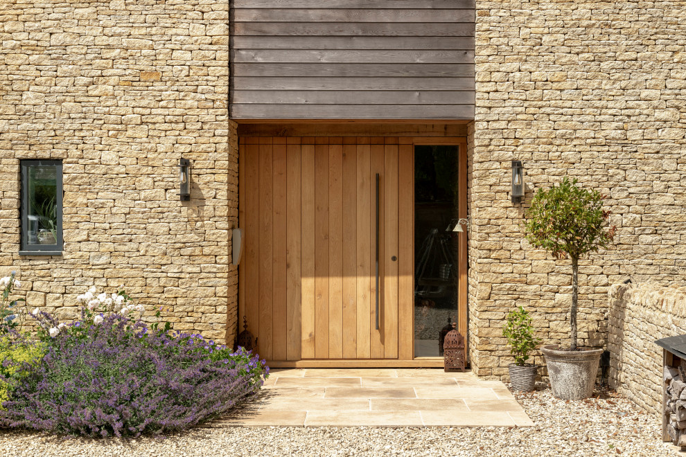 Cette image montre une entrée rustique avec une porte simple et une porte en bois brun.