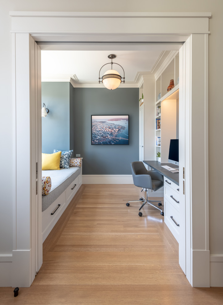 Photo of a transitional study room in San Francisco with a built-in desk, grey walls, medium hardwood floors and brown floor.