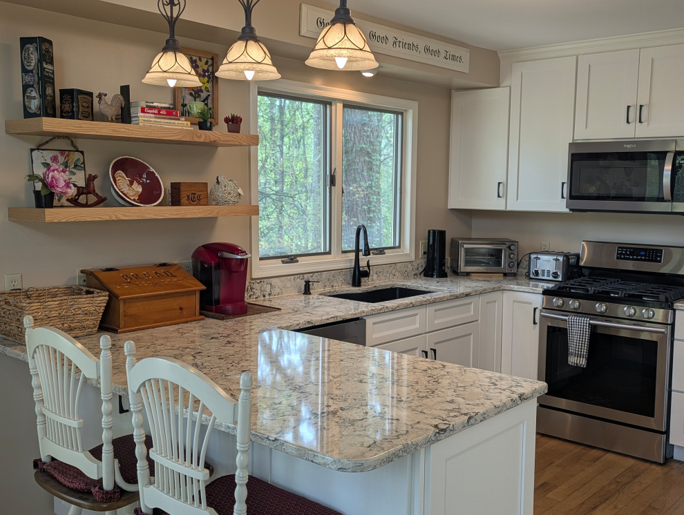 Small transitional u-shaped brown floor eat-in kitchen photo with an undermount sink, flat-panel cabinets and stainless steel appliances