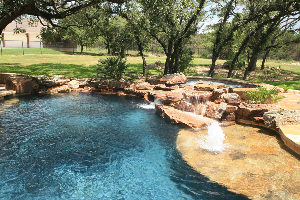 Mid-sized mountain style backyard stone and custom-shaped natural pool fountain photo in Austin