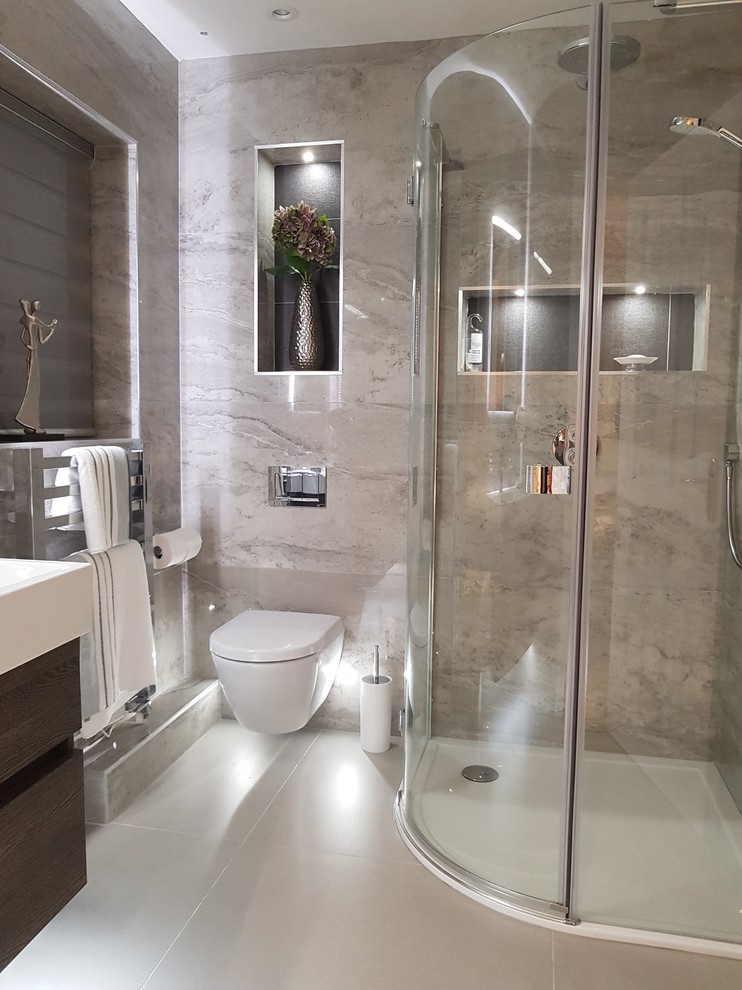 This is an example of a medium sized contemporary ensuite bathroom in Other with flat-panel cabinets, dark wood cabinets, a corner shower, a wall mounted toilet, grey tiles, porcelain tiles, grey walls, porcelain flooring, a wall-mounted sink, grey floors and a hinged door.