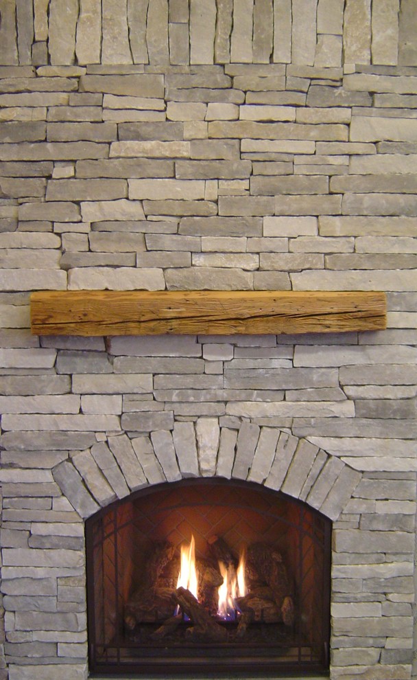 Inspiration for a country living room in Grand Rapids with a standard fireplace and a stone fireplace surround.
