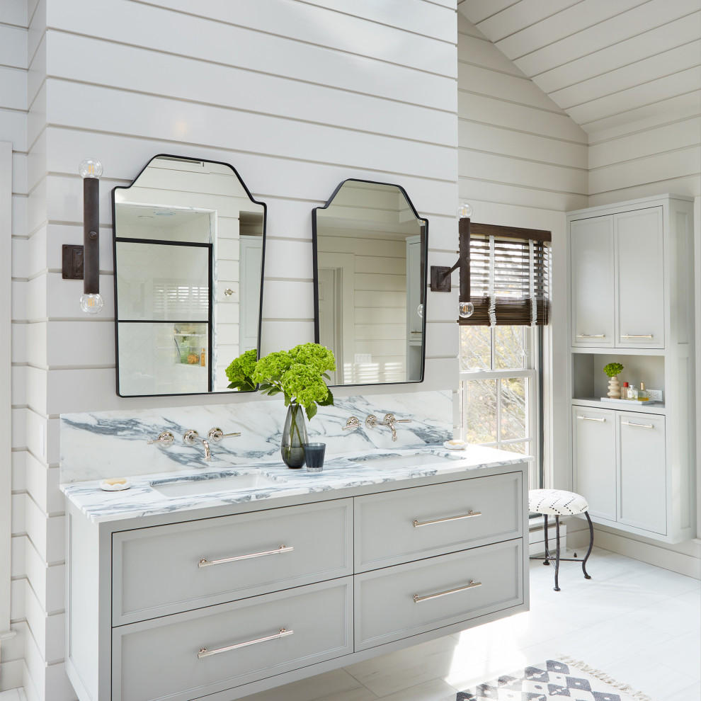 Photo of a large nautical ensuite bathroom in New York with recessed-panel cabinets, white cabinets, a freestanding bath, a built-in shower, white tiles, white walls, marble flooring, a submerged sink, marble worktops, white floors, a hinged door, white worktops, a wall niche, double sinks, a floating vanity unit, a timber clad ceiling and tongue and groove walls.