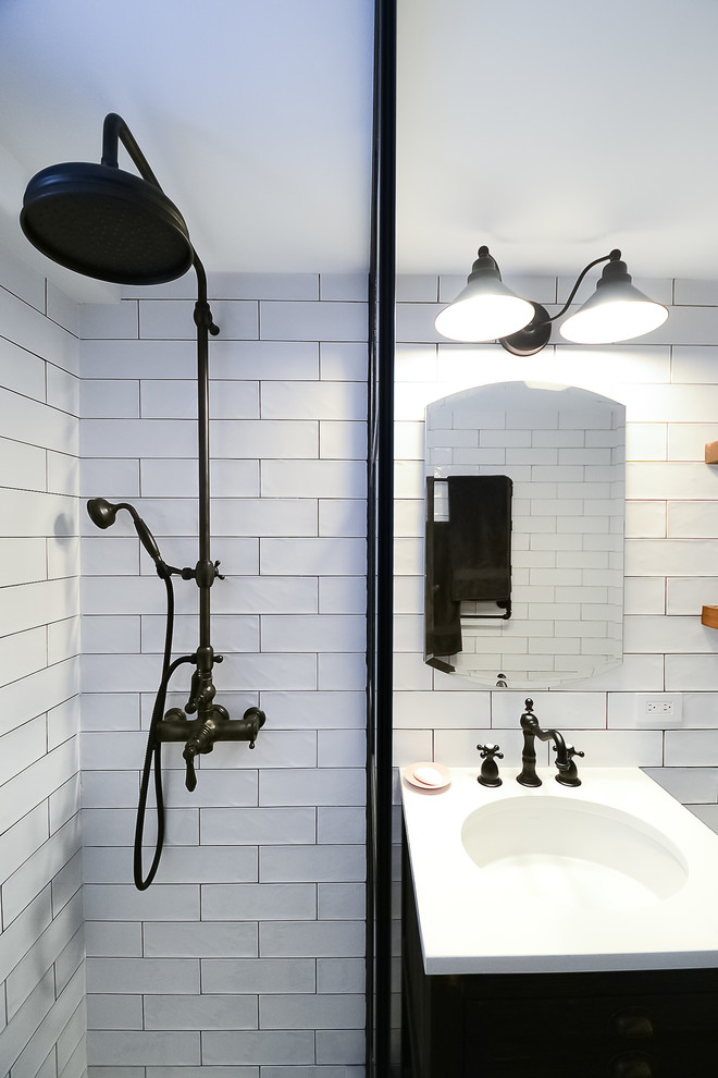 Inspiration for a mid-sized industrial bathroom in New York with furniture-like cabinets, brown cabinets, a double shower, a one-piece toilet, white tile, subway tile, white walls, porcelain floors, a pedestal sink, brown floor, an open shower and white benchtops.