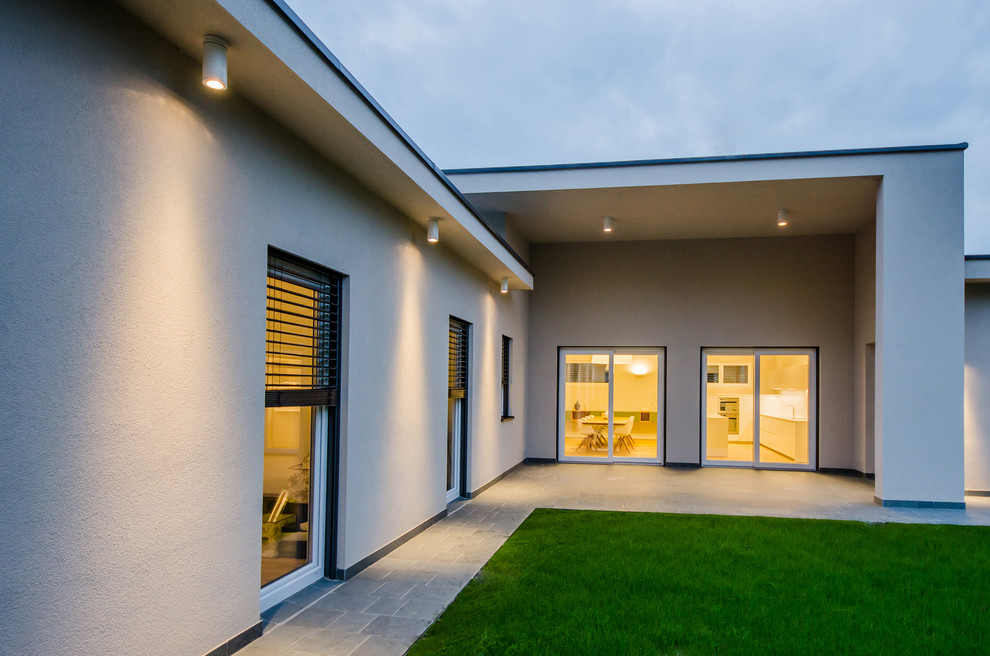 Large contemporary one-storey stucco beige house exterior in Milan with a flat roof.