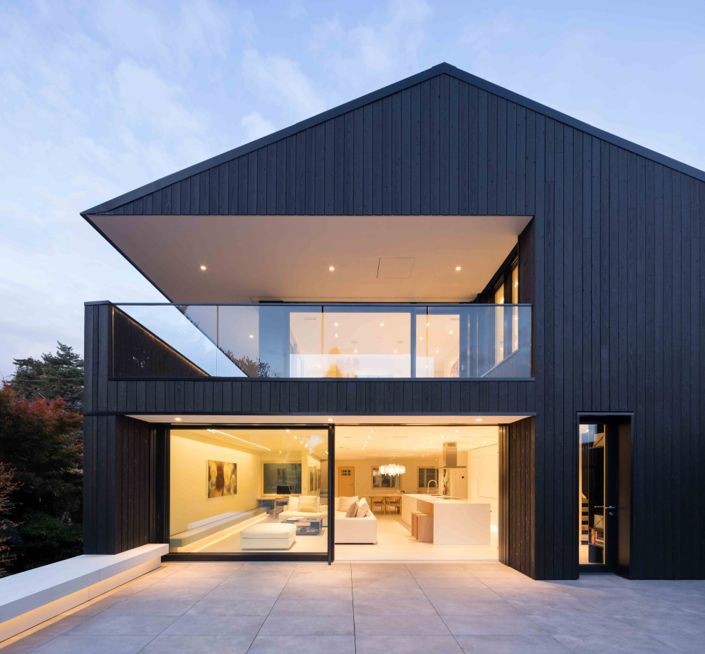Mittelgroßes, Zweistöckiges Modernes Haus mit schwarzer Fassadenfarbe, Blechdach und schwarzem Dach in Vancouver