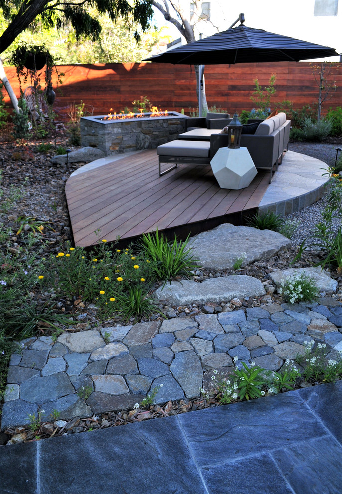 This is an example of a mid-sized asian backyard gravel water fountain landscape in San Diego.