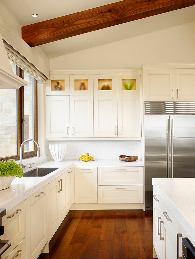 Design ideas for a transitional kitchen in Austin with an undermount sink, recessed-panel cabinets, white splashback, stainless steel appliances, medium hardwood floors and with island.