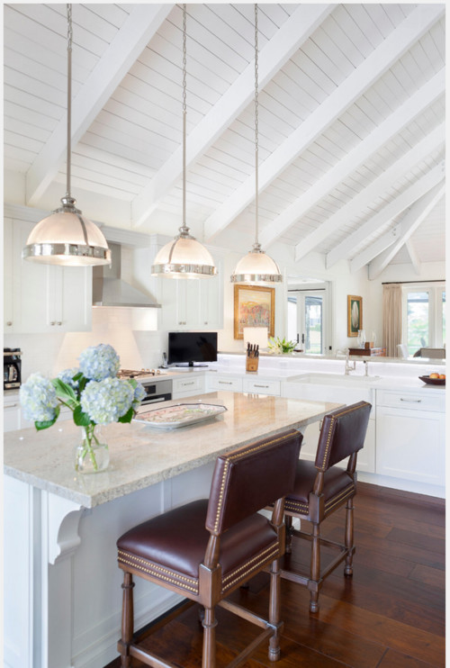 Three white half ball pendant lights hang from a tall vaulted ceiling ...