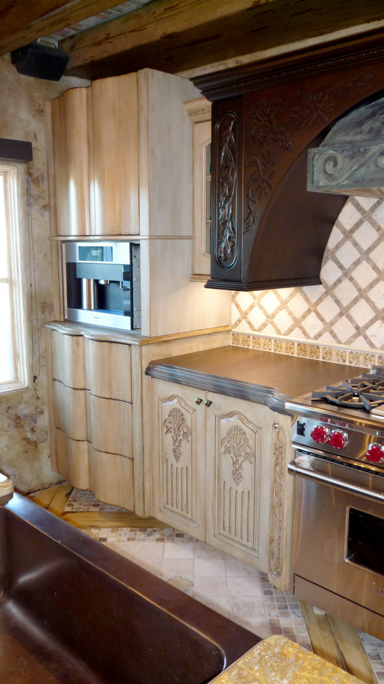Eclectic kitchen photo in Phoenix with beige backsplash, stone tile backsplash, stainless steel appliances and an island