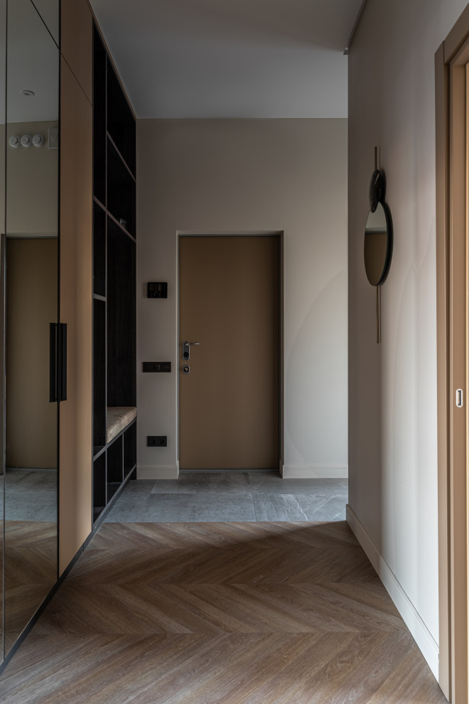 サンクトペテルブルクにあるお手頃価格の中くらいなコンテンポラリースタイルのおしゃれな玄関ホール (白い壁、淡色無垢フローリング、木目調のドア、ベージュの床、壁紙、白い天井) の写真