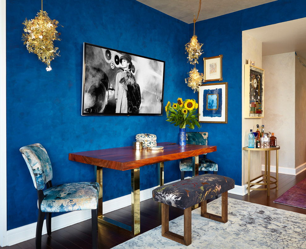 Photo of an eclectic dining room in New York with blue walls and dark hardwood floors.