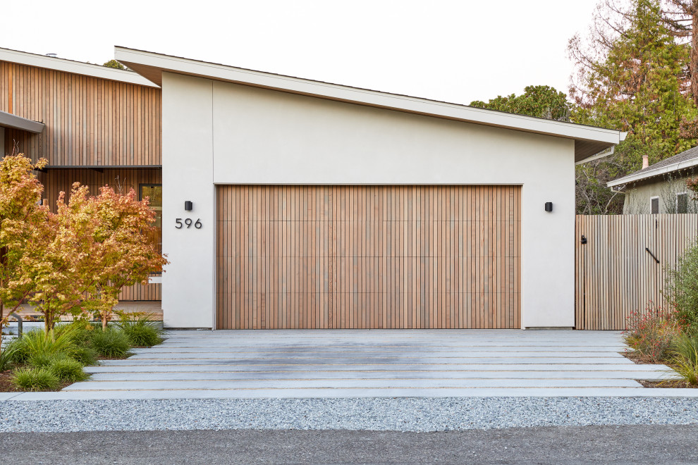 Cette image montre un grand garage pour deux voitures attenant minimaliste.