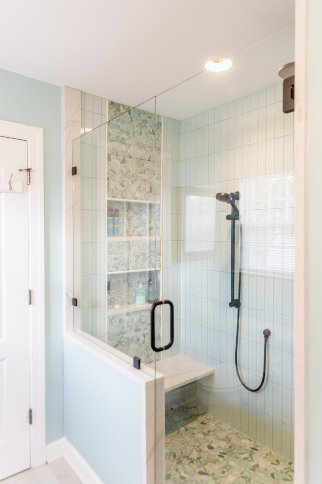 This is an example of a small beach style master bathroom in Charleston with raised-panel cabinets, light wood cabinets, an alcove shower, a two-piece toilet, green tile, porcelain tile, green walls, porcelain floors, an undermount sink, engineered quartz benchtops, beige floor, a hinged shower door, white benchtops, a shower seat, a single vanity and a built-in vanity.