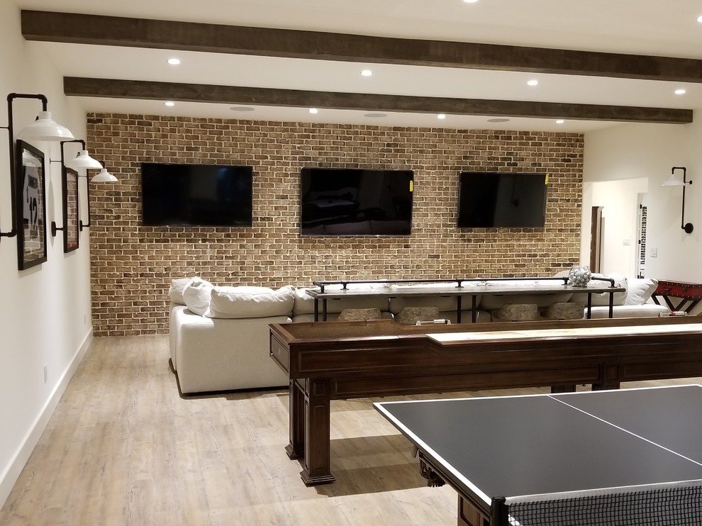 This is an example of a large traditional fully buried basement in Atlanta with white walls, light hardwood floors, no fireplace and brown floor.