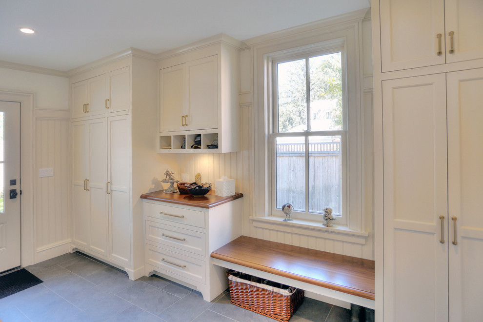 Photo of a mid-sized traditional mudroom in Bridgeport with beige walls, porcelain floors, a single front door, a white front door, grey floor and decorative wall panelling.