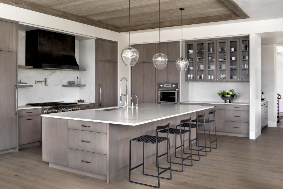 Example of a mountain style medium tone wood floor and wood ceiling kitchen design with an undermount sink, flat-panel cabinets, white backsplash, an island and white countertops