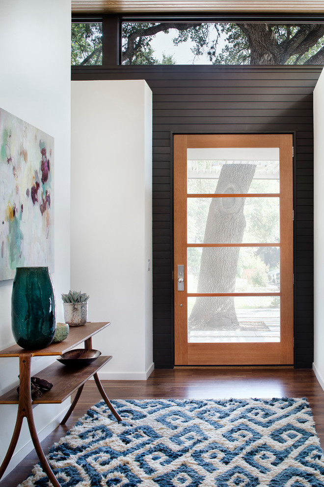 Inspiration for a large contemporary front door in Austin with white walls, dark hardwood floors, a single front door and a glass front door.