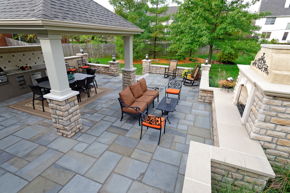 This is an example of an expansive transitional backyard patio in Columbus with an outdoor kitchen, natural stone pavers and a gazebo/cabana.