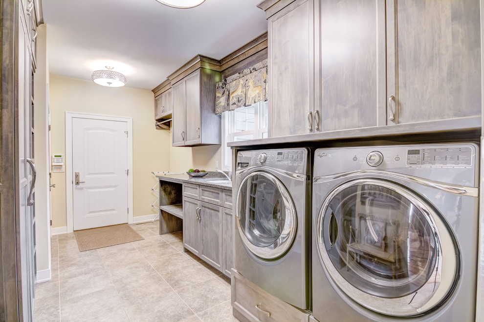 Inspiration for a large traditional laundry room in Other with an undermount sink, shaker cabinets, grey cabinets, granite benchtops, beige walls, ceramic floors, a side-by-side washer and dryer and grey floor.