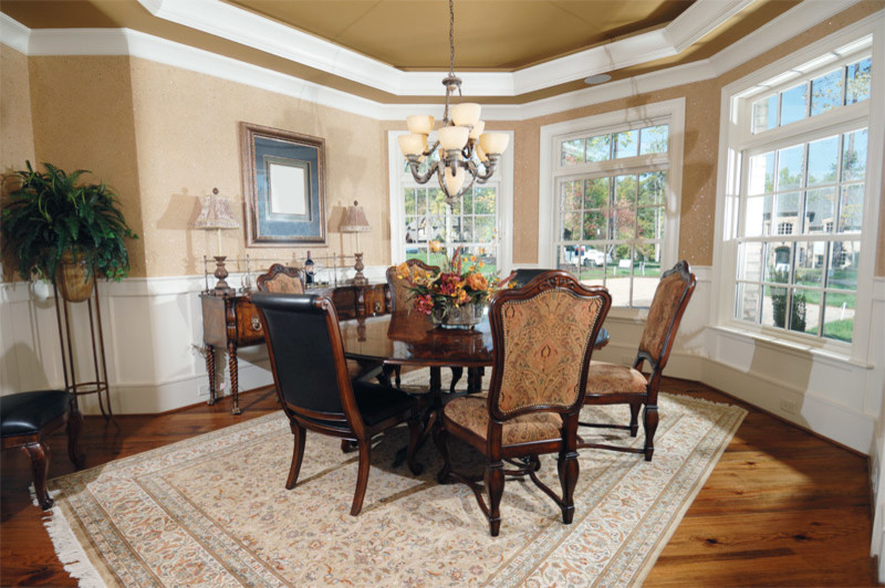 This is an example of a mid-sized traditional dining room in Houston with beige walls and medium hardwood floors.
