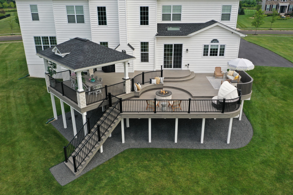Immagine di una terrazza minimalista di medie dimensioni, dietro casa e al primo piano con un focolare e parapetto in metallo