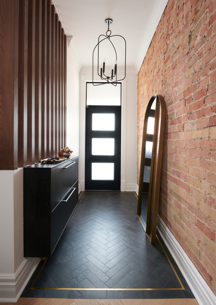 トロントにある高級な小さなコンテンポラリースタイルのおしゃれな玄関ロビー (白い壁、磁器タイルの床、黒いドア、黒い床、レンガ壁) の写真