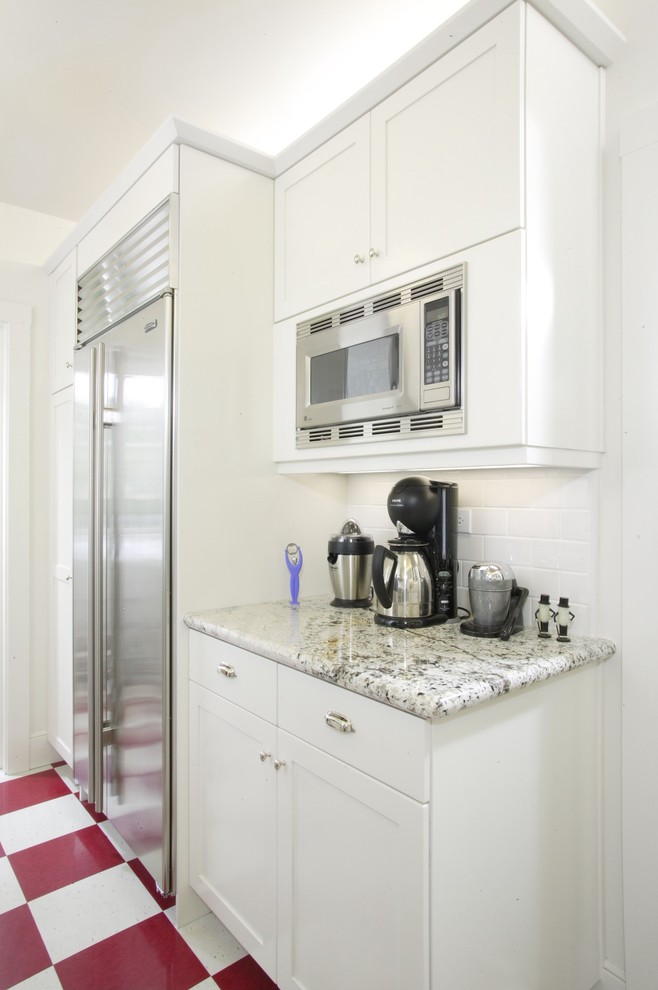 Mid-sized traditional l-shaped separate kitchen in Sacramento with an undermount sink, shaker cabinets, white cabinets, granite benchtops, white splashback, subway tile splashback, stainless steel appliances, ceramic floors and no island.
