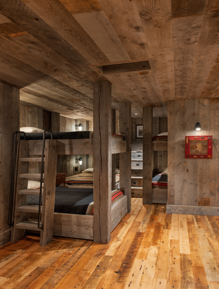Inspiration for a rustic guest medium tone wood floor, brown floor, wood ceiling and wood wall bedroom remodel in Other with brown walls and no fireplace