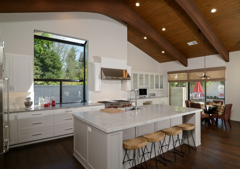 Inspiration for a large transitional single-wall open plan kitchen in Sacramento with white cabinets, marble benchtops, white splashback, dark hardwood floors and with island.