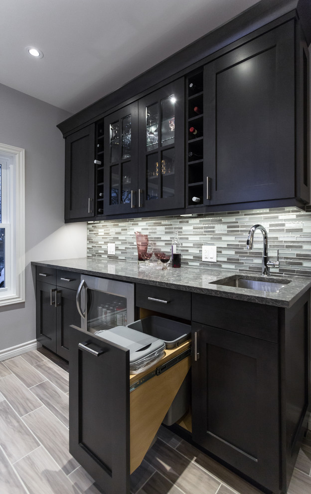 Mid-sized trendy porcelain tile and gray floor kitchen photo with an undermount sink, shaker cabinets, gray cabinets, solid surface countertops, multicolored backsplash, matchstick tile backsplash and stainless steel appliances
