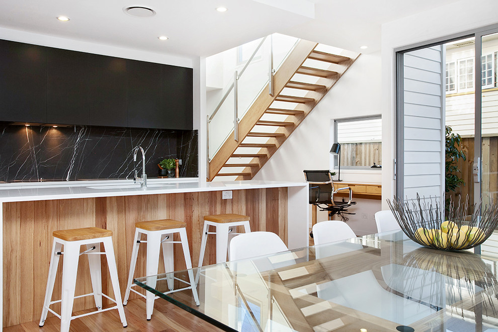 Inspiration for a scandinavian kitchen in Brisbane with an undermount sink, black cabinets, marble benchtops, black splashback, marble splashback, stainless steel appliances, medium hardwood floors and with island.